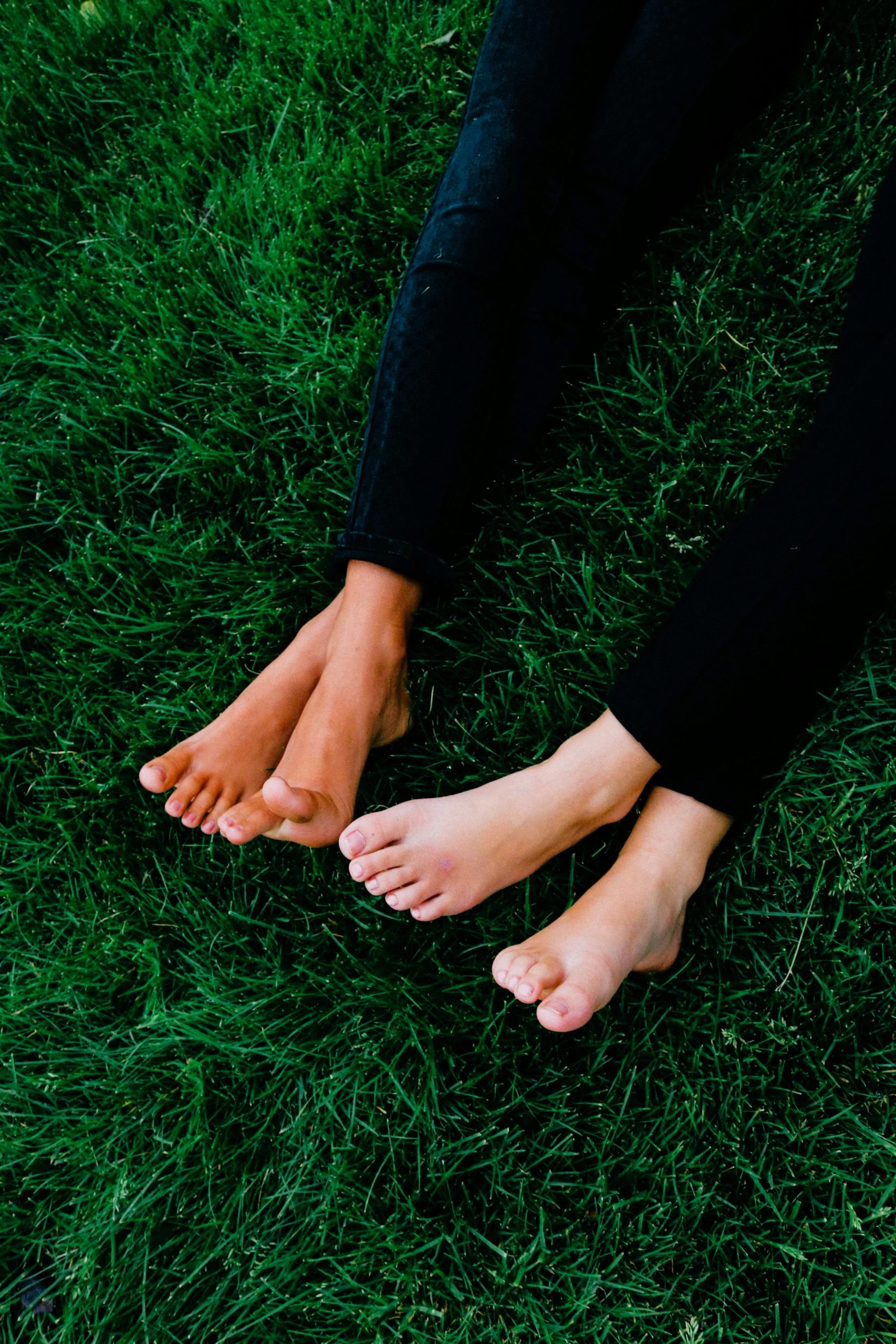 Female legs casually lying on vibrant green grass