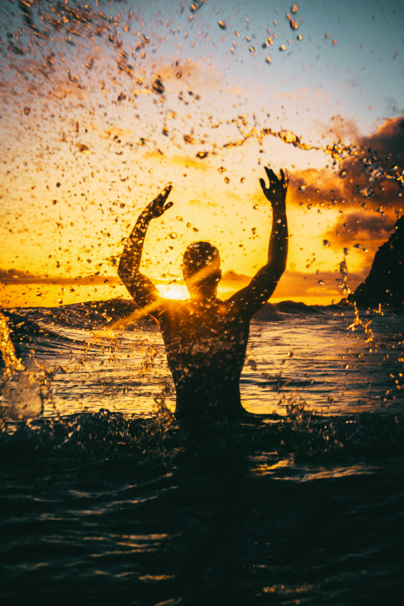 A person swimming at sunrise, embracing the Sun's vital energy.