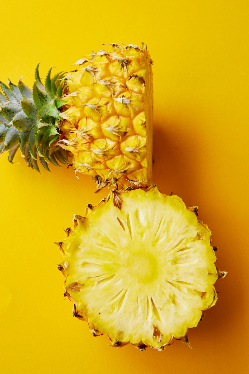 A vibrant, freshly cut pineapple with its golden-yellow flesh exposed.