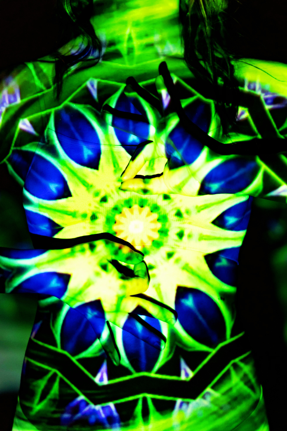 A female figure surrounded by a dynamic, multi-colored aura