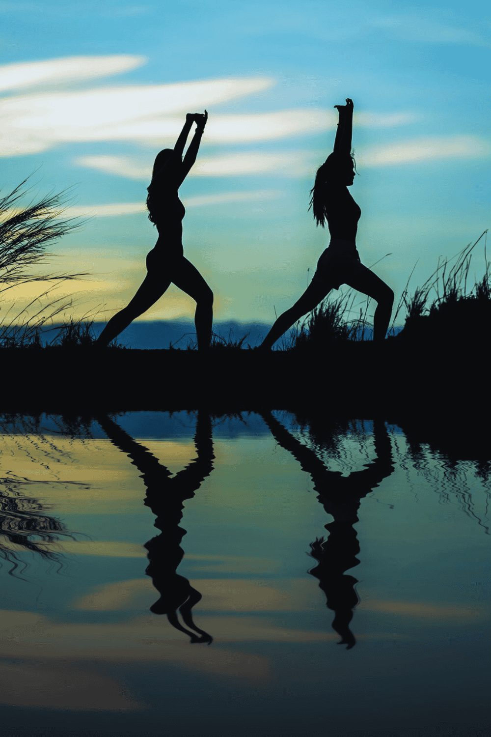 Silhouettes of two women engaged in a yoga sequence