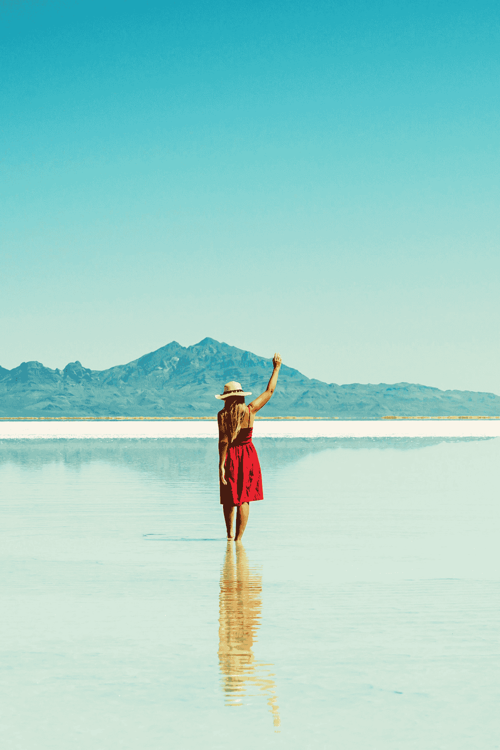 lady in red dress on the sea shore